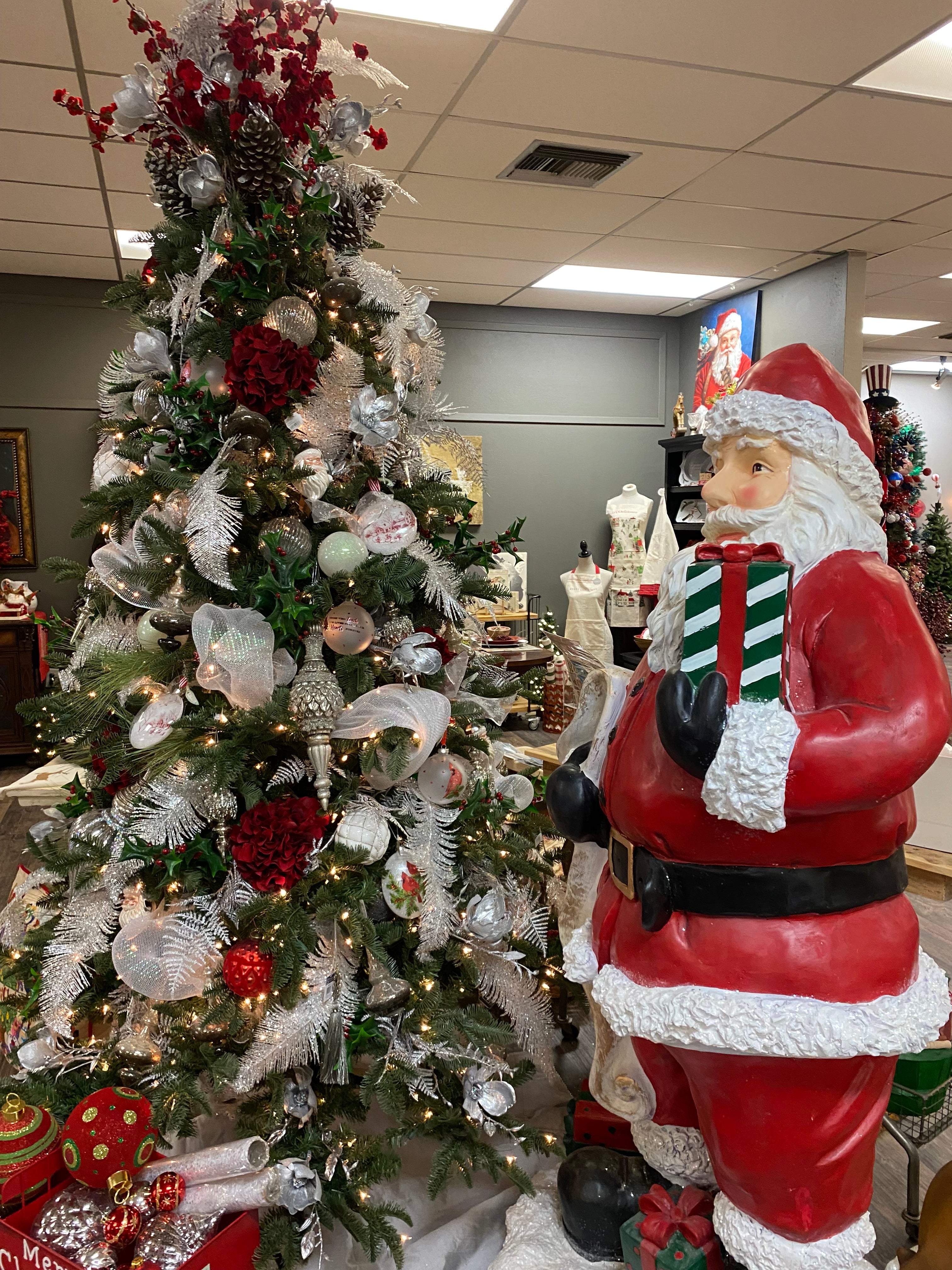 Decorated Christmas tree with a large Santa Claus figure in a retail store.