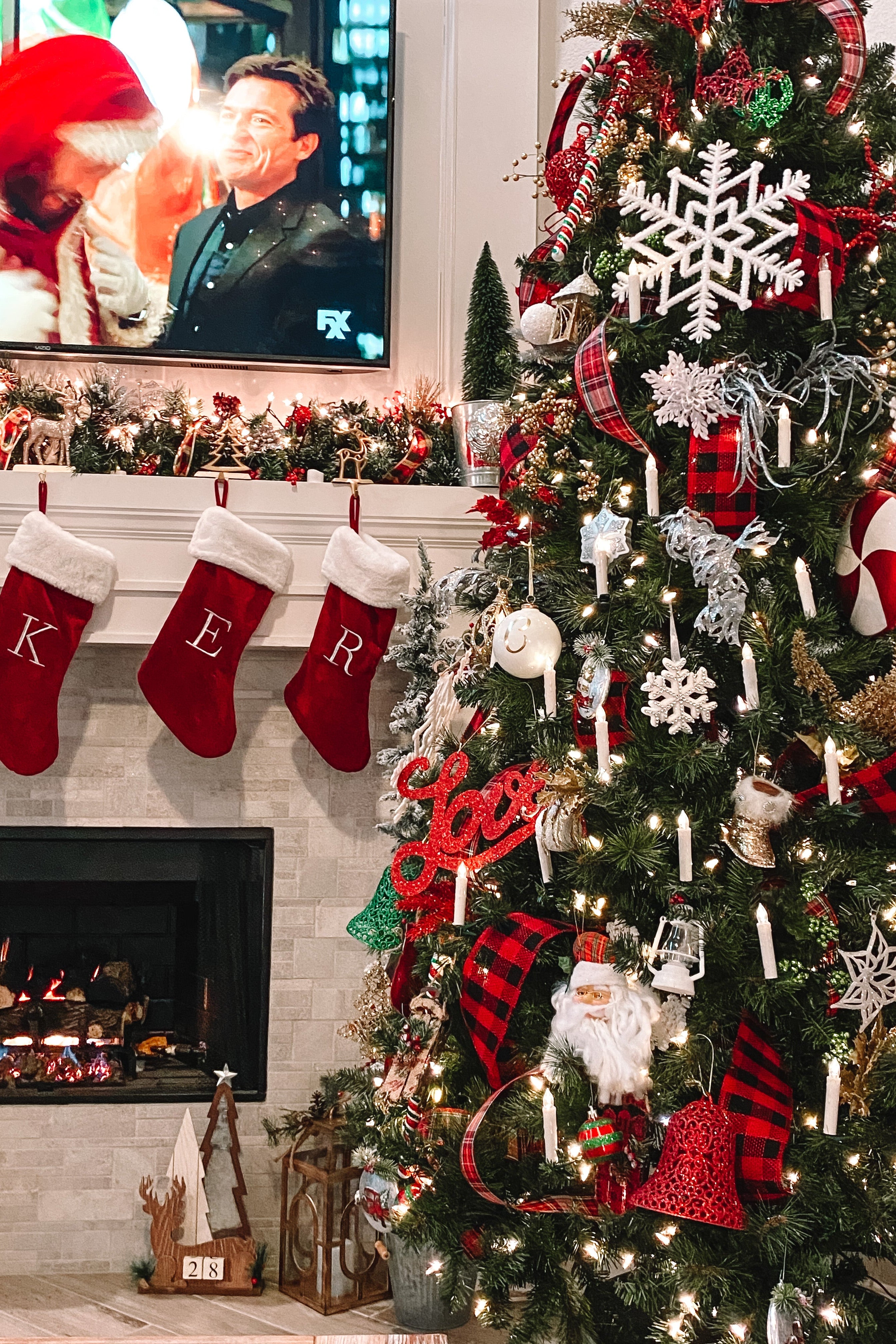 Decorated Christmas tree with stockings and a fireplace in the background